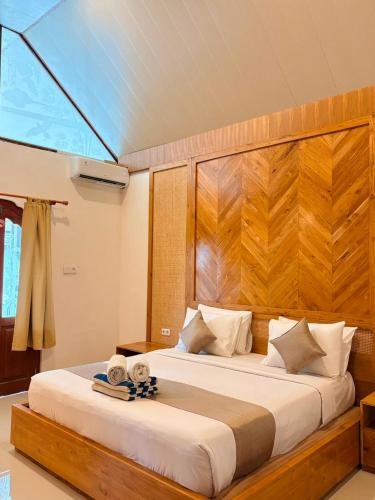 a bedroom with a large bed with a wooden headboard at Kusnadi Hotel in Legian