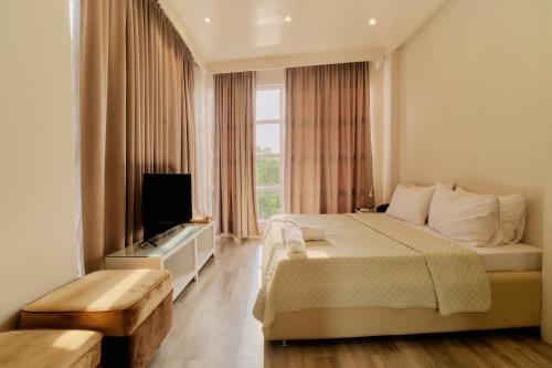 a bedroom with a large bed and a television at Pitstop Mango Grove Retreat in Guimaras