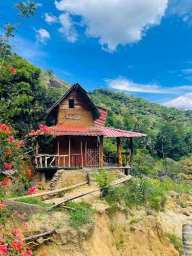 a small house on a hill with flowers at Clay house in Kurukohogama