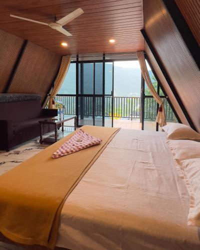 a large bed in a room with a balcony at Tribez Valley Resort in Anaviratty