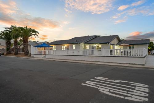 a house with a white fence and palm trees at Entire Private Home with Yard, King Bed, Prime Location, 3 Bedrooms 3 Bathrooms, Available Now in San Diego