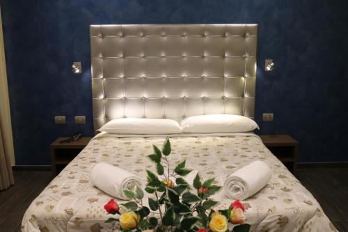 a bedroom with a large bed with a large headboard at Hotel La Madonnina in Milan