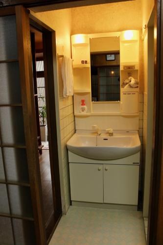 a bathroom with a sink and a mirror at Jizo House in Kyoto