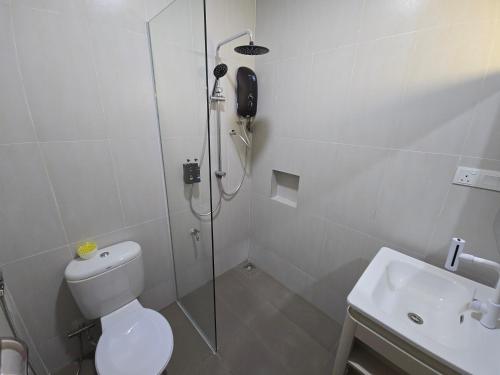 a bathroom with a shower and a toilet and a sink at One Point Hotel TT3 Tabuan Tranquility in Kuching