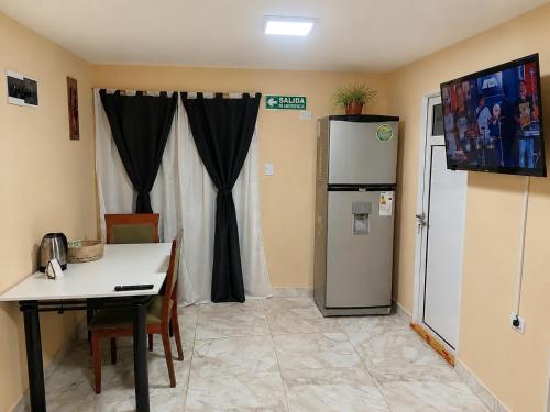 a kitchen with a table and a refrigerator in a room at Apartamento Patagonia in Puerto San Julián