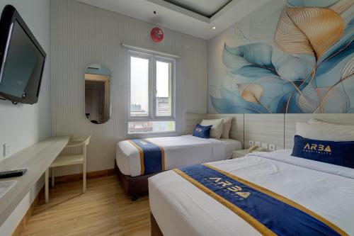 a hotel room with two beds and a tv at Hotel Bunga-Bunga By ARBA in Jakarta
