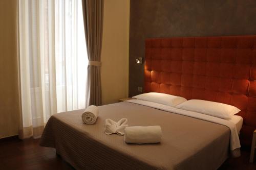 a bedroom with a large bed with two towels on it at Hotel La Madonnina in Milan
