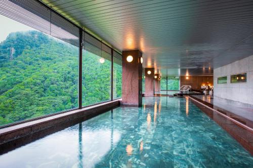 a swimming pool with a view of a mountain at Choyo Tei in Kamikawa
