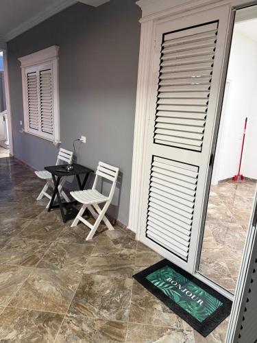 a dining room with a table and chairs and a window at Vila Muhadri in Kamëz