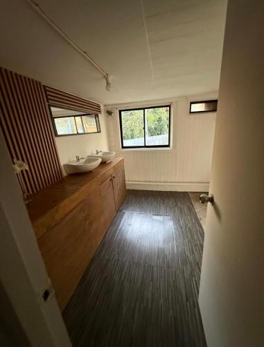 a bathroom with two sinks and a large window at Hostal Casa Trancura in Pucón