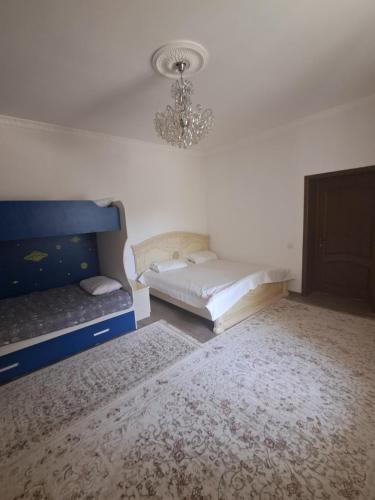 a bedroom with two beds and a chandelier at Rancho Otel Almaty in Qaskeleng