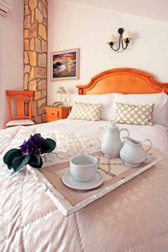 a tray with a tea set on a bed at Hotel Casa Rosa in Benalmádena