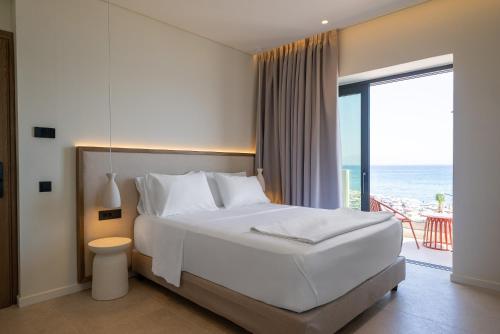 a bedroom with a bed with a view of the ocean at The Palms Kos in Kos
