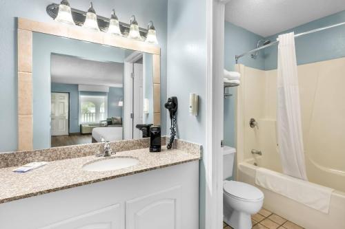 a bathroom with a sink and a toilet and a mirror at Quality Inn in Barbourville