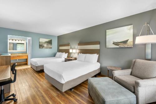 a hotel room with two beds and a desk at Quality Inn in Barbourville