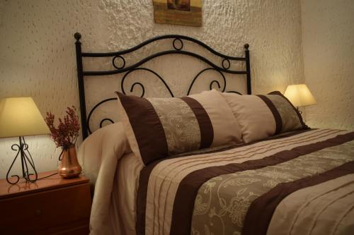 a bedroom with a large bed and two lamps at Apartamentos Horno y Casa De Dulce in Purullena