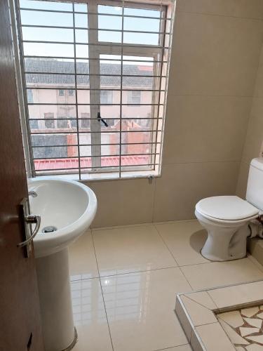 a bathroom with a toilet and a sink and a window at 42 On Canterbury in Durban