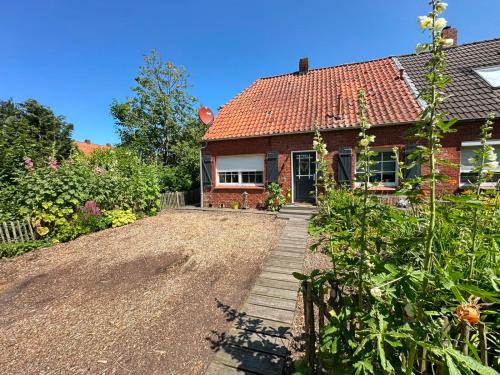 a house with a gravel driveway in front of it at Huus an`t Dörpsdiek in Krummhörn