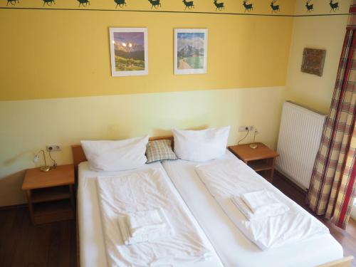 a bedroom with a large white bed with two tables at Apartment am Christopherhof in Grafenwiesen