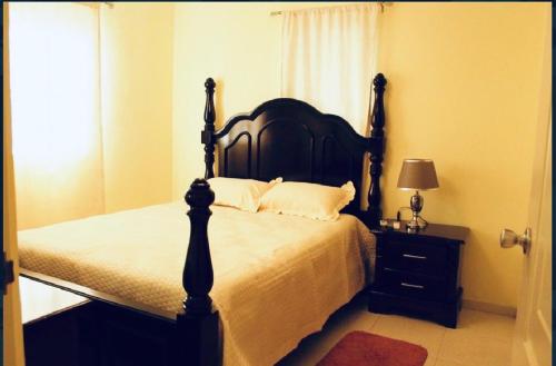 a bedroom with a large bed with a black headboard at Confortable in San Isidro