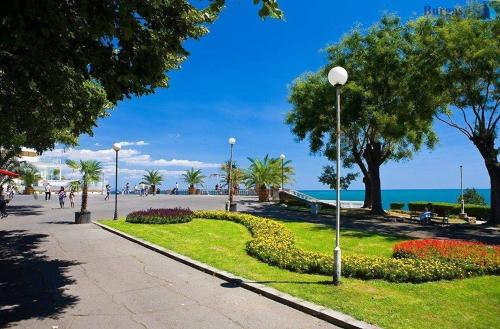 un parque junto a la playa con árboles y flores en Guest House Elit en Burgas