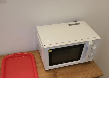 a microwave sitting on a table next to a red chair at Pokoje Gościnne u Marcina, Gästezimmer bei Martin in Mielno
