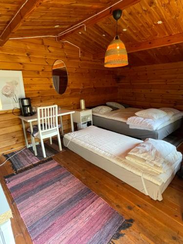 a bedroom with two beds and a desk in a cabin at Solberga red cottage in Solberga