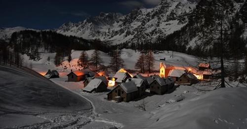 a group of buildings in the snow at night at Casa Fattorini in Baceno