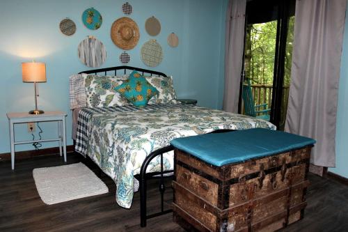 a bedroom with a bed and a table and a window at Rustic Tree Top Cabin in Sky Valley, Georgia in Sky Valley