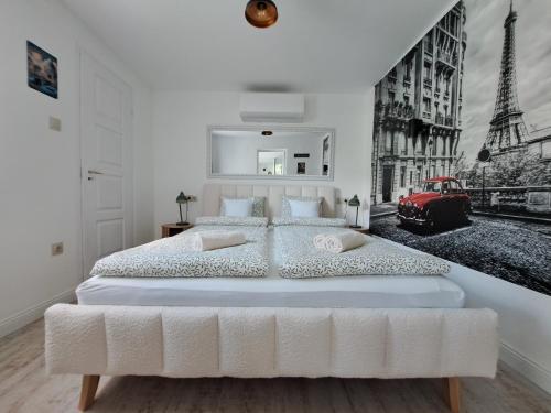 a bedroom with a large white bed with a red car at Kúria Apartman Extra in Budapest