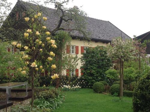 einen Garten vor einem Haus mit Blumen in der Unterkunft Haus Probst am See in Schondorf am Ammersee