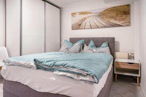a bedroom with a bed with a blue blanket at Ferienapartment 2 Heimathafen in Seedorf
