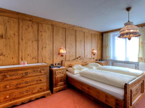 sypialnia z dużym łóżkiem i drewnianymi ścianami w obiekcie Pension Walkerbach w Lech am Arlberg