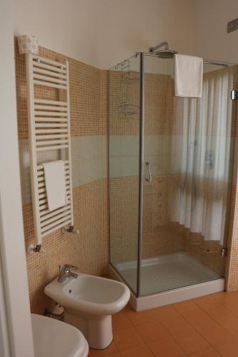 a bathroom with a shower and a toilet and a sink at Hotel La Madonnina in Milan