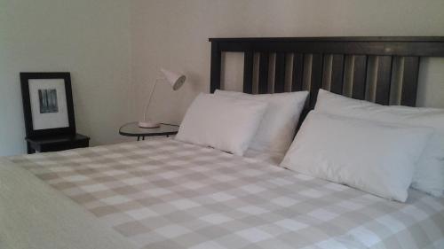 a bedroom with a bed with white pillows and a lamp at Casa Fattorini in Baceno