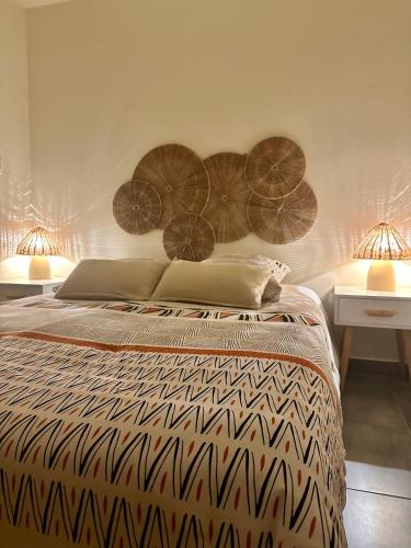 a bedroom with a bed and two tables and two lamps at Au cocon du verdon, T2 in Gréoux-les-Bains