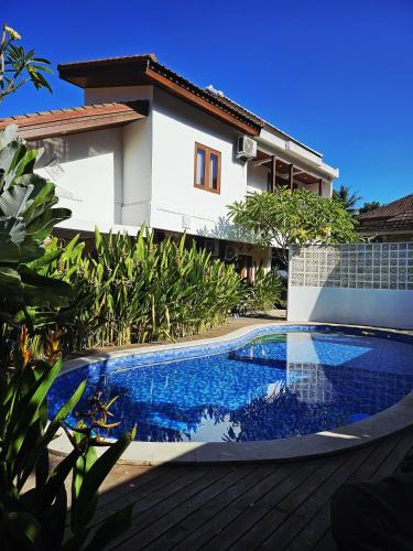 a swimming pool in front of a house at Lantis Corp Inn in Sengkol