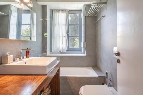 a bathroom with a sink and a tub and a toilet at Spetses Estia Orloff in Spetses