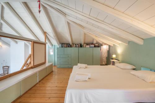 two beds in a large room with white ceilings at Spetses Estia Orloff in Spetses
