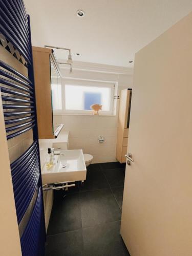 a bathroom with a sink and a toilet and a window at Ferien in der Flurstraße in Velbert