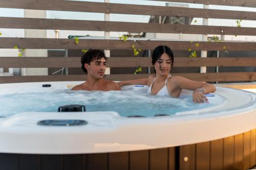a man and a woman sitting in a hot tub at Il Panoramico - Terrazza e Jacuzzi in Neviano