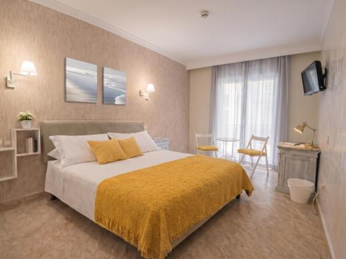 a bedroom with a large bed with a yellow blanket at Hotel Playa del Carmen in Barbate