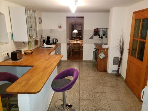 a kitchen with purple bar stools in a room at Ferienhaus Herzogenreuth in Heiligenstadt