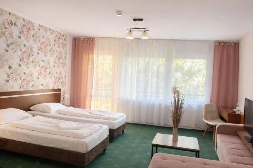 a hotel room with two beds and a couch at Trojak Mysłowice in Mysłowice