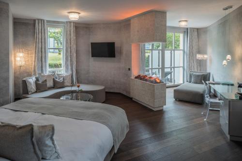 a bedroom with a large bed and a living room at Parkhotel Adler in Hinterzarten