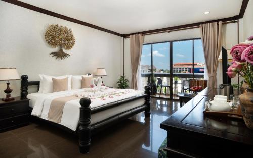 a bedroom with a large bed and a balcony at The Heritage Courtyard in Siem Reap