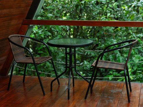 a table and two chairs on a porch with a window at Pozas y Cascadas La Presa Habitación 2 in Ángeles