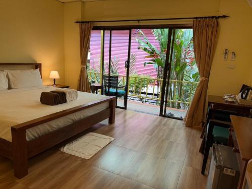 a bedroom with a bed and a sliding glass door at Chaweng Bliss Bungalow in Chaweng