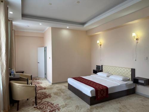 a bedroom with a bed and a desk and a chair at Tsetsenkhangai Hotel in Ulaanbaatar