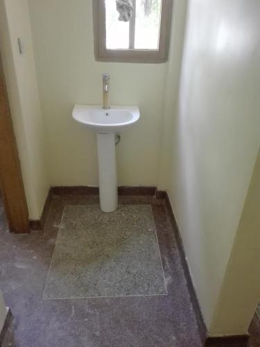 a bathroom with a white sink and a window at The Paradise In Kilimanjaro in Moshi